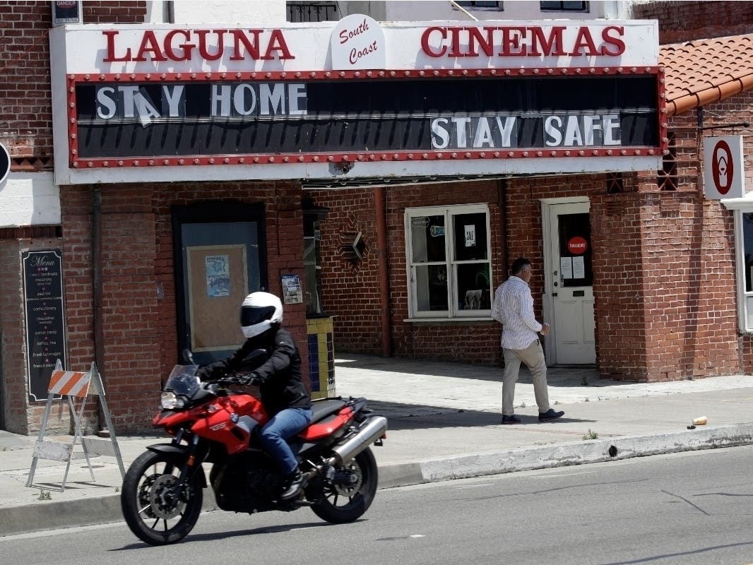A sign encourages people to stay home Sunday, May 3, 2020, in Laguna Beach, Calif. 
