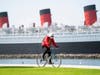 A bicyclist wearing a face mask rides past The Queen Mary hotel Monday, May 11, 2020, in Long Beach, Calif.