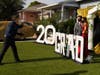 Gabriel Lopez, center, and Delilah Santos, right, have their pictures and video taken by Philippe Michel in front of the home of Diane Scott during the coronavirus outbreak, Saturday, May 16, 2020, in Los Angeles. 
