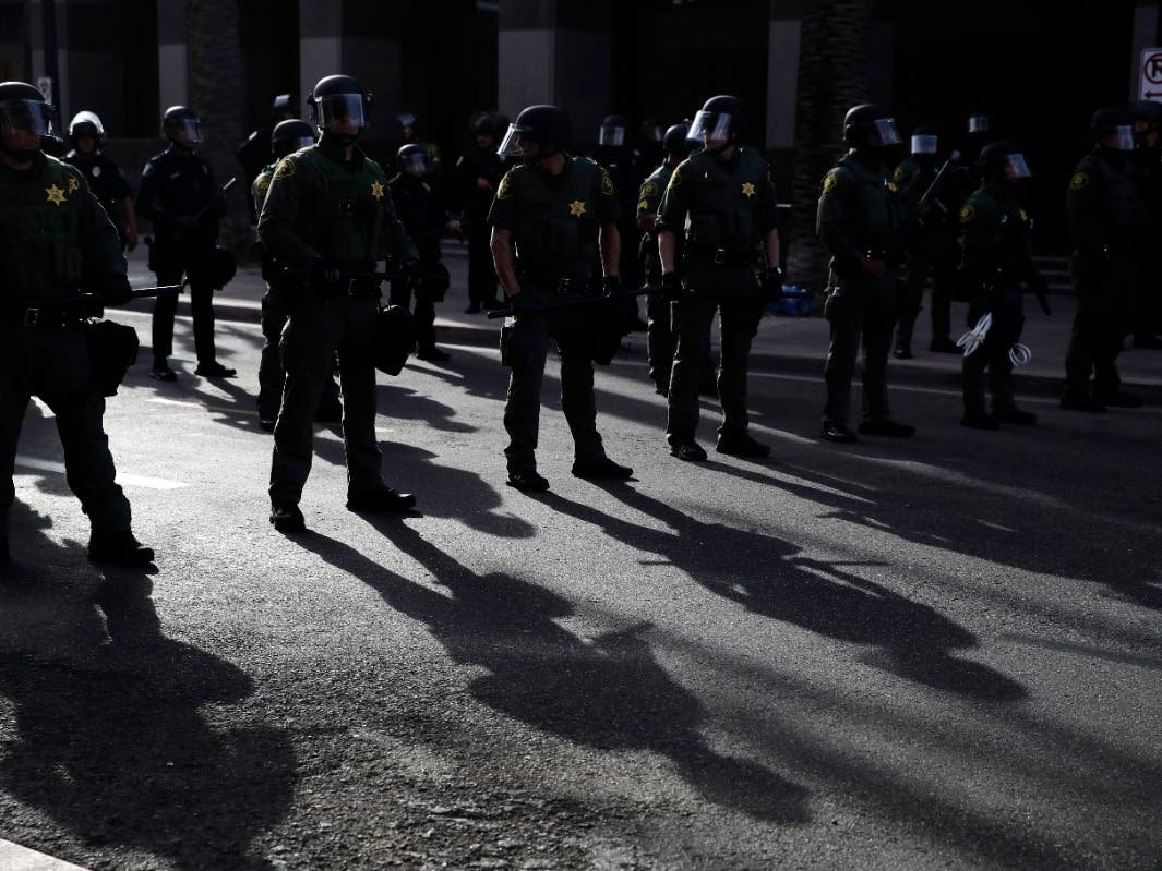 Orange County sheriff's deputies cast shadows as they stand guard during a protest Monday, June 1, 2020, in Anaheim, Calif., over the death of George Floyd on May 25 in Minneapolis.