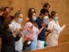 Family members hold hands as they pray at the first English Mass with faithful present at the Cathedral of Our Lady of the Angels in downtown Los Angeles, Sunday, June 7, 2020. Catholic parishes throughout Los Angeles had suspended public mass in March.