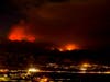 The Apple Fire burns behind mountains near Beaumont, Calif., Sunday, Aug. 2, 2020.