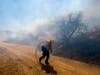 A firefighter runs as the wind blows at the Apple Fire in Banning, Calif., Sunday, Aug. 2, 2020.