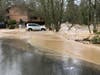 An apartment building is flooded by overflowing Issaquah Creek, right, in Issaquah, Wash., as heavy rains pound the area Thursday, Feb. 6, 2020. 