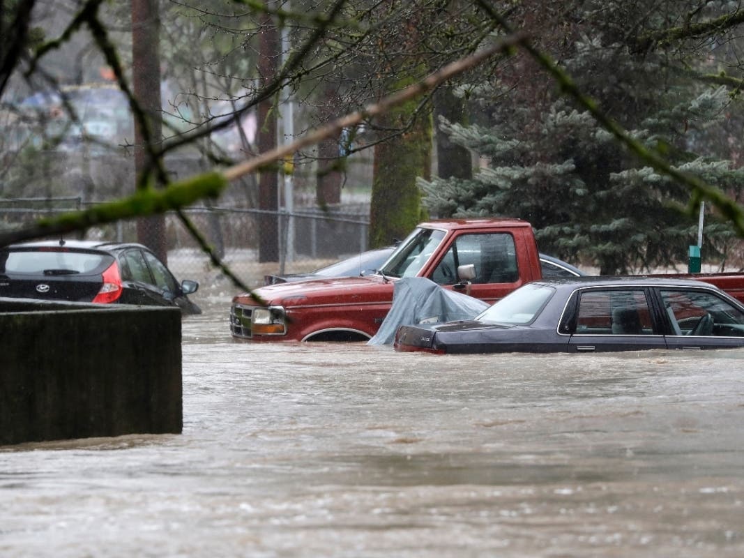 Cars parked at an apartment building are submerged in flood waters of Issaquah Creek Thursday, Feb. 6, 2020, in Issaquah, Wash.
