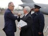 Vice President Mike Pence, center, greets Washington Gov. Jay Inslee, left, as Pence arrives, Thursday, March 5, 2020 at Joint Base Lewis-McChord in Washington state. Officials are avoiding handshakes due to the COVID-19 coronavirus.