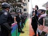 Protesters hold hands in front of a line of police officers blocking a street Wednesday, July 1, 2020, in Seattle, where streets had been blocked off in an area demonstrators had occupied for weeks.