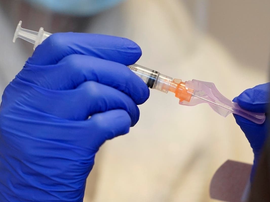 A pharmacist working for the Seattle Indian Health Board holds a syringe of the Moderna COVID-19 vaccine, Monday, March 15, 2021, at a SIHB clinic in Seattle.