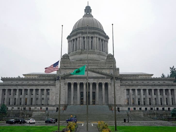 Flags in front of the Legislative Building fly at half-staff, Thursday, Jan. 6, 2022, at the Capitol in Olympia, Wash.