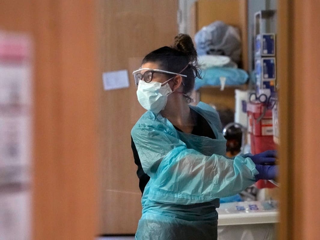 Registered nurse Jessalynn Dest looks across the room while treating a COVID-19 patient in the acute care unit of Harborview Medical Center on Jan. 14 in Seattle.