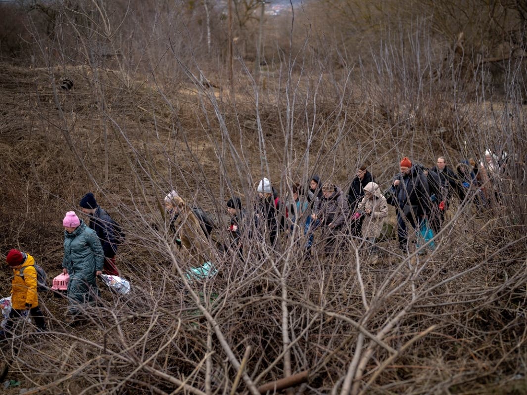 Ukrainian citizens flee crossing the Irpin river in the outskirts of Kyiv, Ukraine, Saturday, March 5, 2022. 