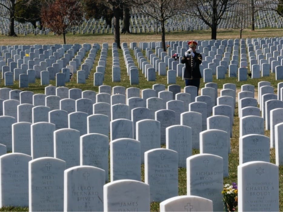  In this Thursday, March 28, 2019, file photo, a military bugler plays taps during a funeral at Arlington National Cemetery in Arlington.