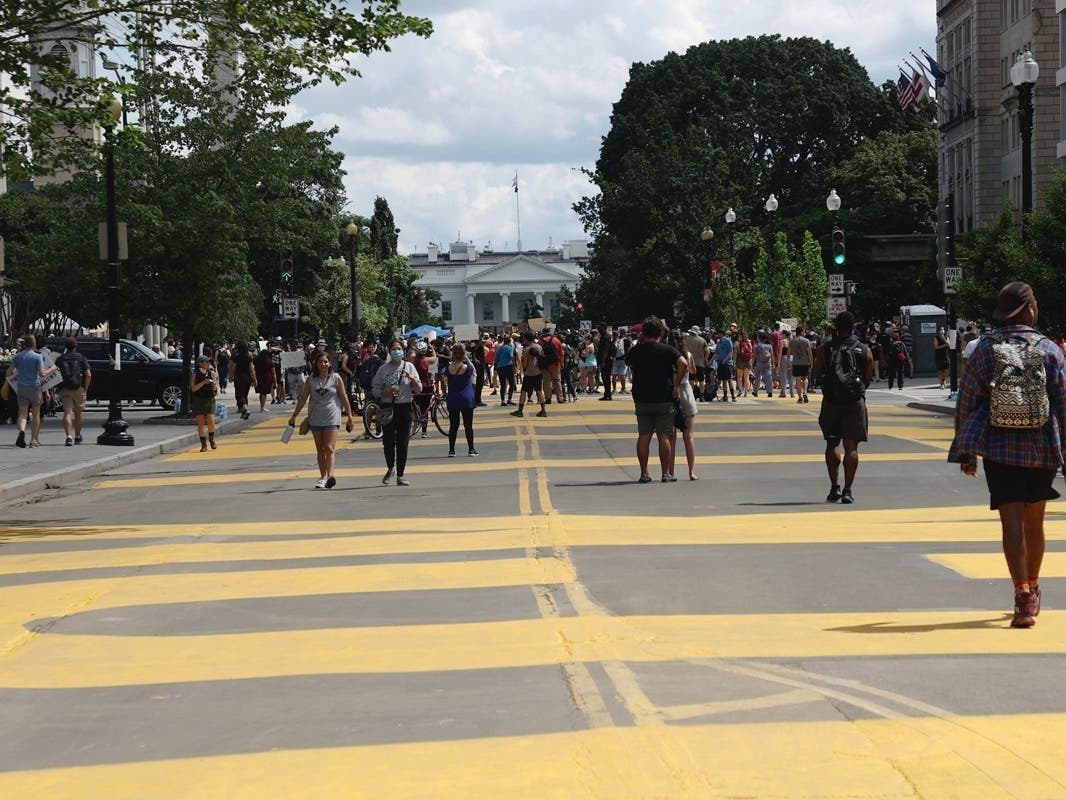 Protestors seen as DC Mayor Muriel Bowser has 'Black Lives Matter' painted on the street leading to the White House and renamed the streets Black Lives Matter Plaza on June 5