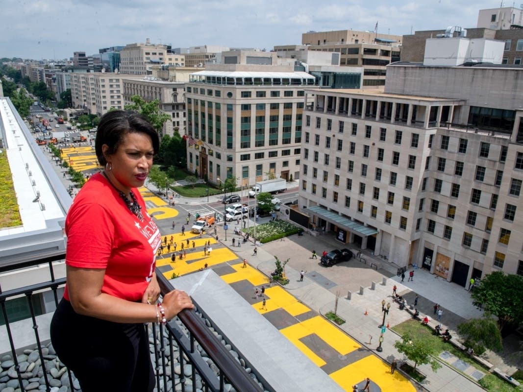 Mayor Muriel Bowser stands on the rooftop of the Hay Adams Hotel near the White House and looks out at the words 'Black Lives Matter' that have been painted in bright yellow letters on the street by city workers and activists, Friday, June 5.