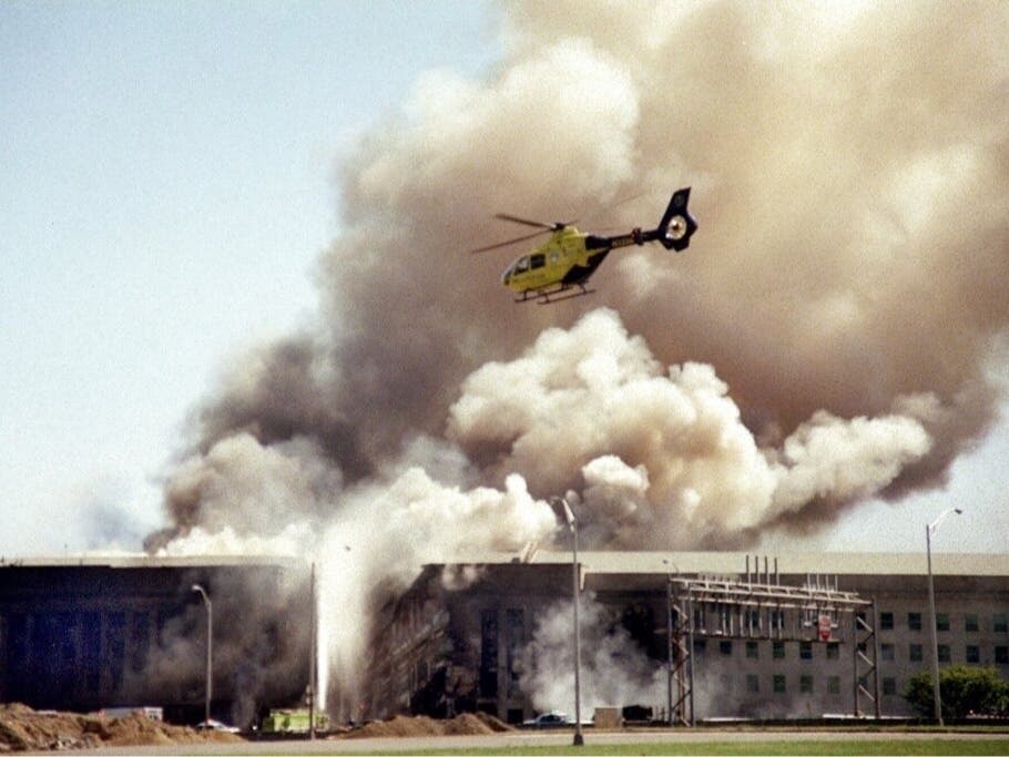 In this Sept. 11, 2001 file photo, a helicopter flies over the Pentagon in Washington as smoke billows over the building. The terrorist-hijacked airliner that slammed into the west side of the Pentagon killed 184 people.