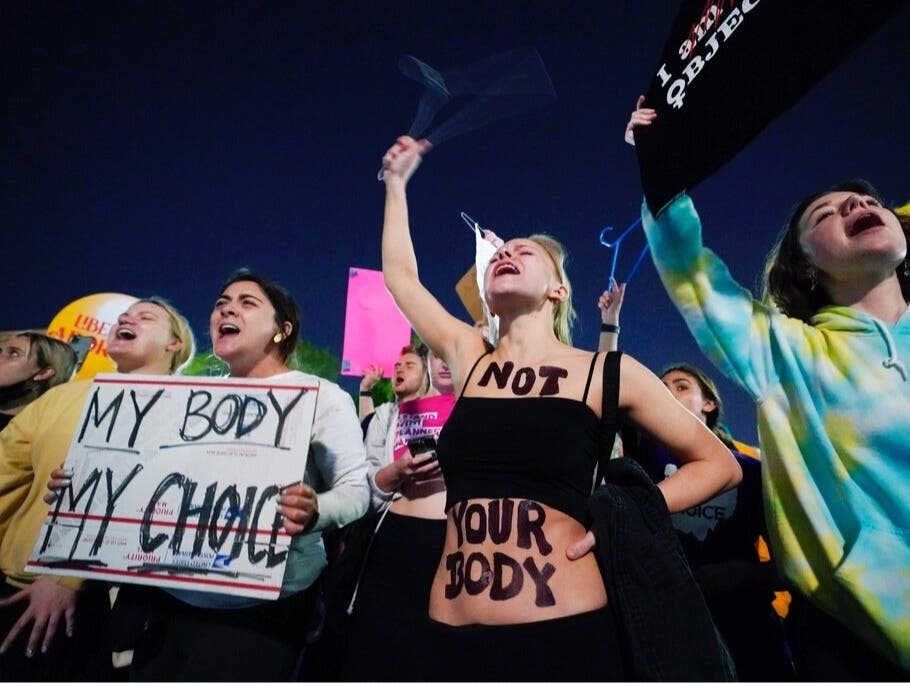 A crowd of people gather outside the Supreme Court early Tuesday in Washington. A draft opinion circulated among Supreme Court justices suggests that earlier this year a majority of them had thrown support behind overturning Roe v. Wade.
