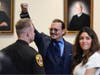 Actor Johnny Depp gestures to spectators in court after closing arguments at the Fairfax County Circuit Courthouse in Fairfax on Friday, May 27.