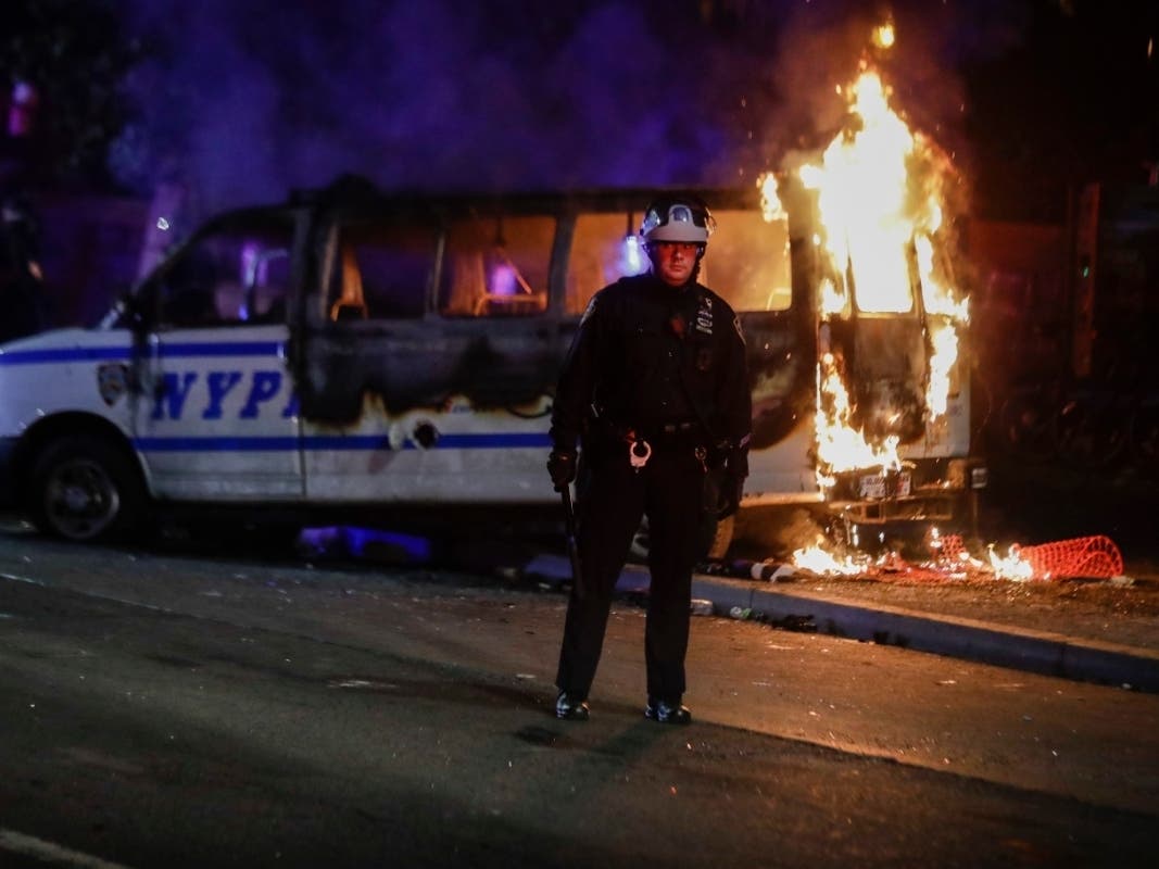 A NYPD van burns in Fort Greene during Friday night demonstrations over the killing of George Floyd. A pair of lawyers are accused of throwing a Molotov cocktail into another police vehicle.