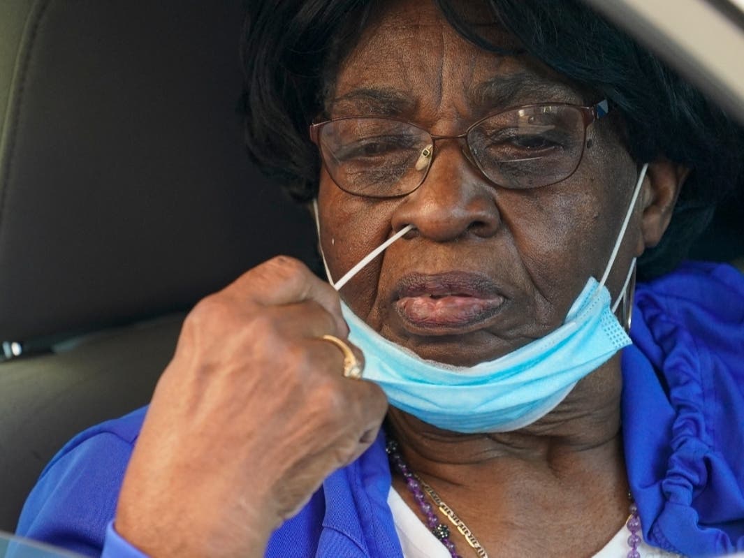 A resident uses a swab to take a coronavirus test at the Central Family Life Center on Tuesday in the Stapleton neighborhood of the Staten Island.