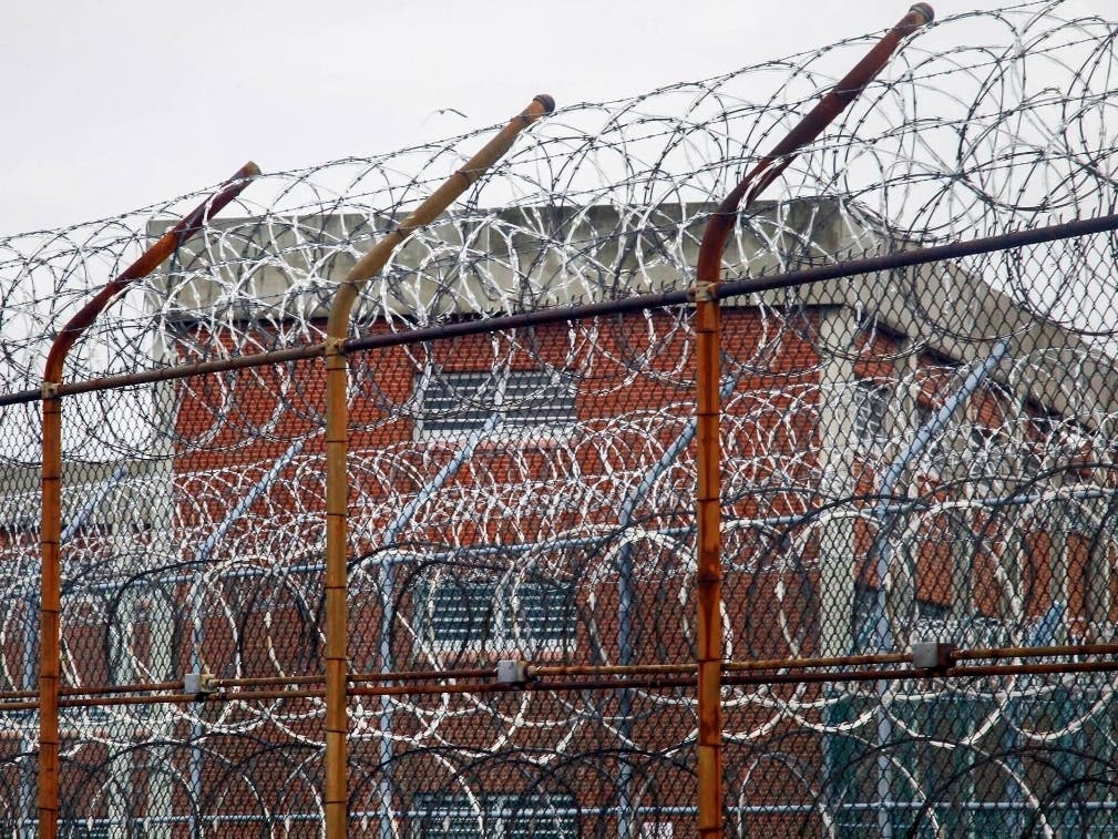 This March 16, 2011 file photo shows a barbed wire fence outside inmate housing on Rikers Island. New York City’s notorious Rikers Island jail complex, troubled by years of neglect, has spiraled into turmoil during the coronavirus pandemic.