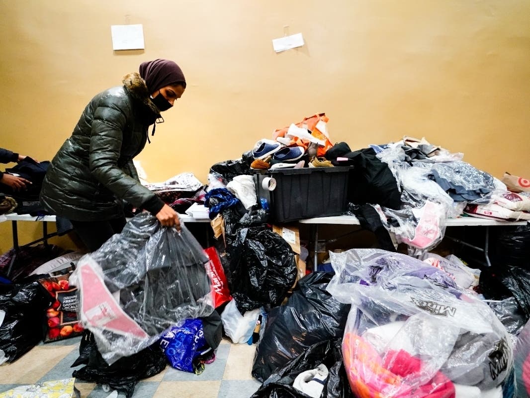A volunteer Monday sorts donations at the Gambian Youth Organization for people affected by city's deadliest fire in three decades in the Bronx.