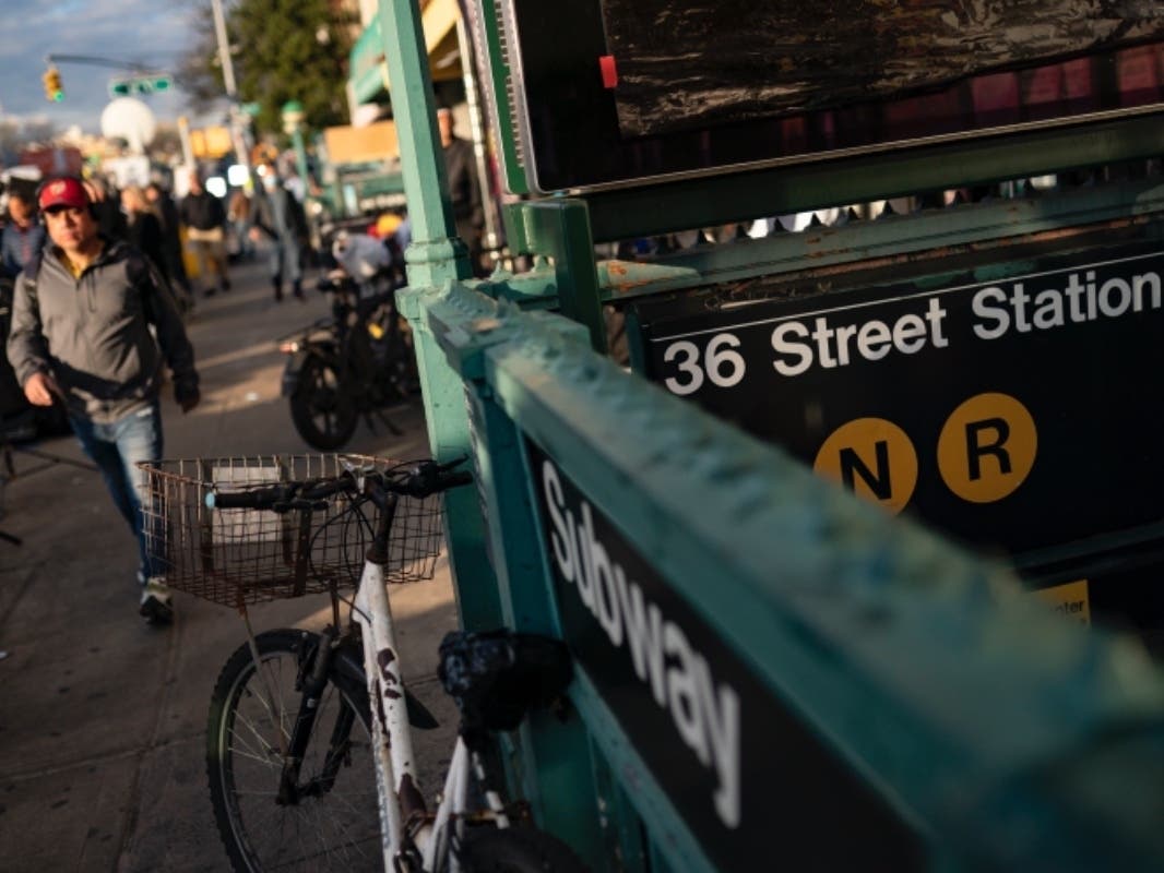 Pedestrians pass the 36th Street subway station where a shooting attack occurred the previous day during the morning commute Wednesday.