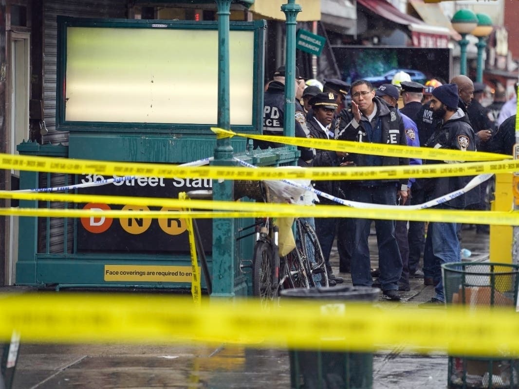 NYPD personnel gather at the entrance to a subway stop in Brooklyn on April 12.