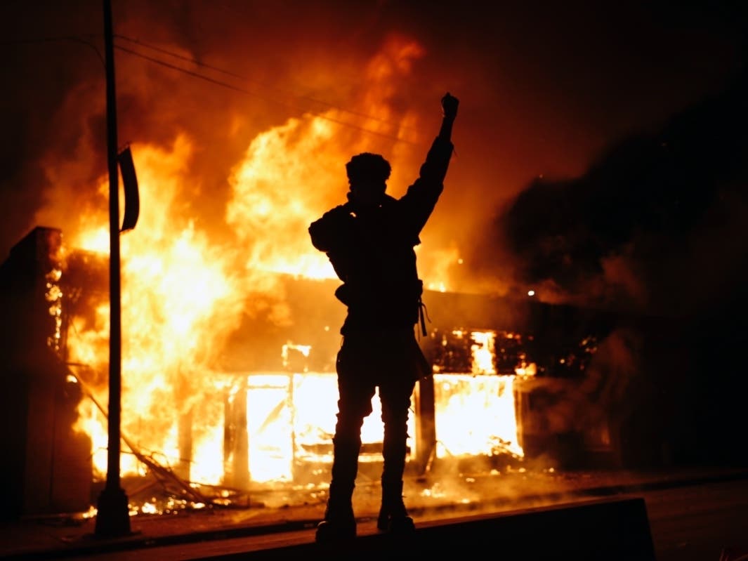 In this May 29, 2020, photo, a check-cashing business burns during protests in Minneapolis. Protests continued following the death of George Floyd, who died after being restrained by Minneapolis police officers on Memorial Day.