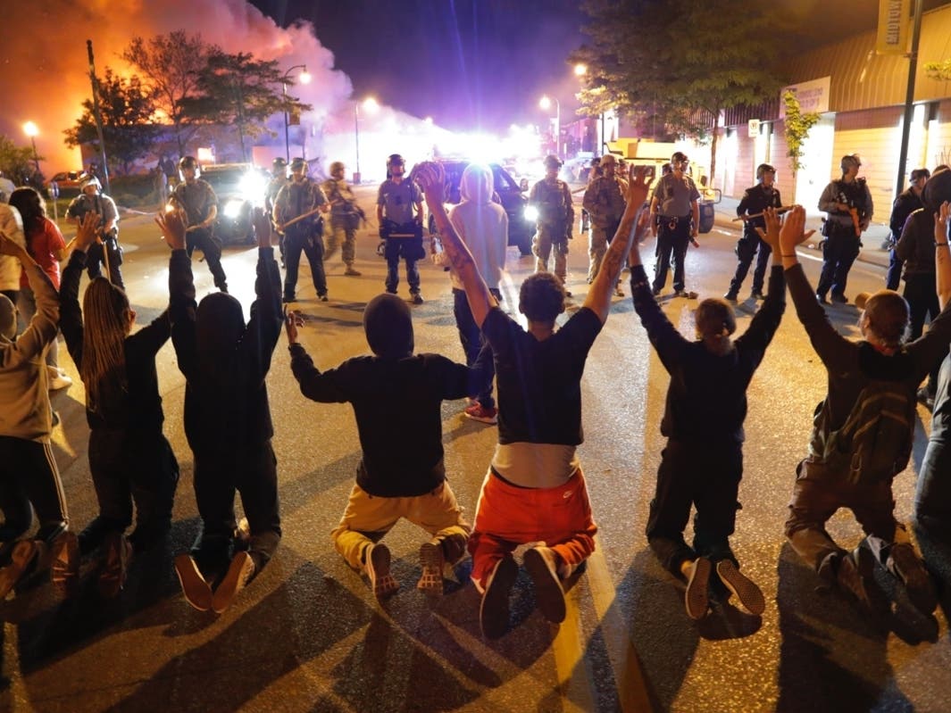 Demonstrators kneel before police Saturday, May 30, 2020, in Minneapolis. Protests continued following the death of George Floyd, who died after being restrained by Minneapolis police officers on Memorial Day. 