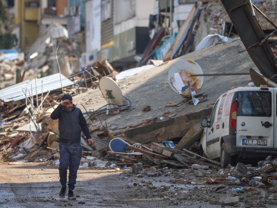 A man walks past destroyed buildings in Antakya, southeastern Turkey, Tuesday. 