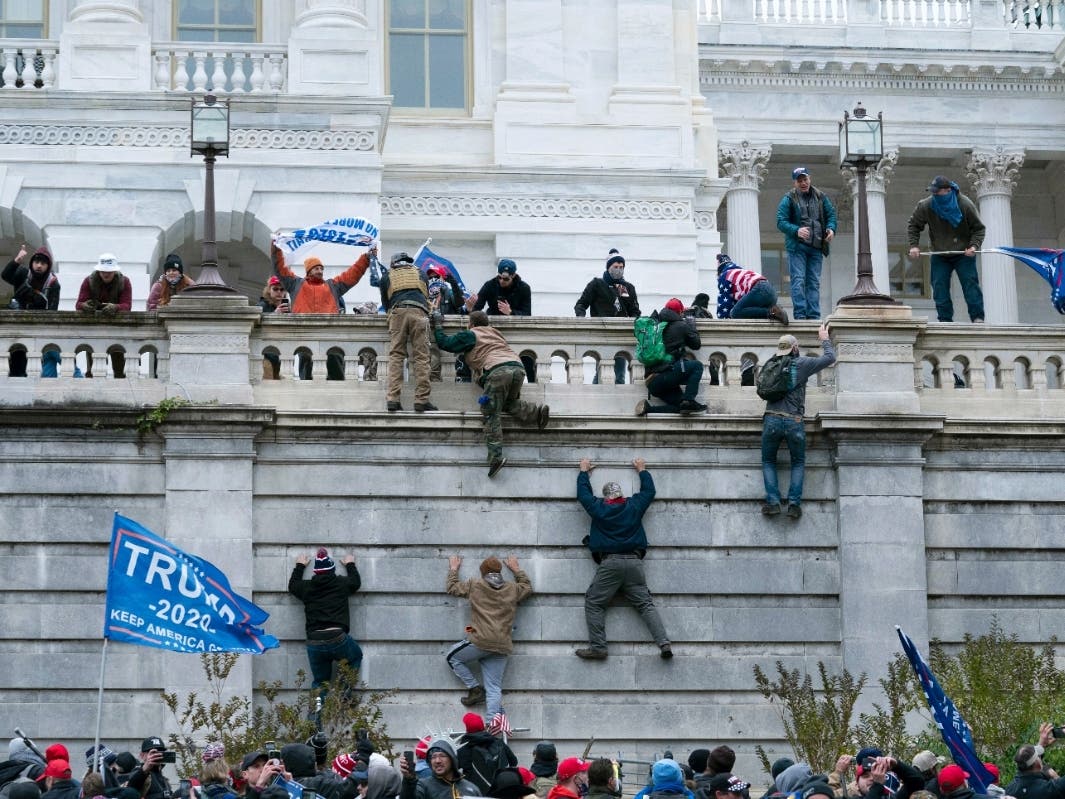 Supporters of President Donald Trump climb the west wall of the the U.S. Capitol on Jan. 6 in Washington. 