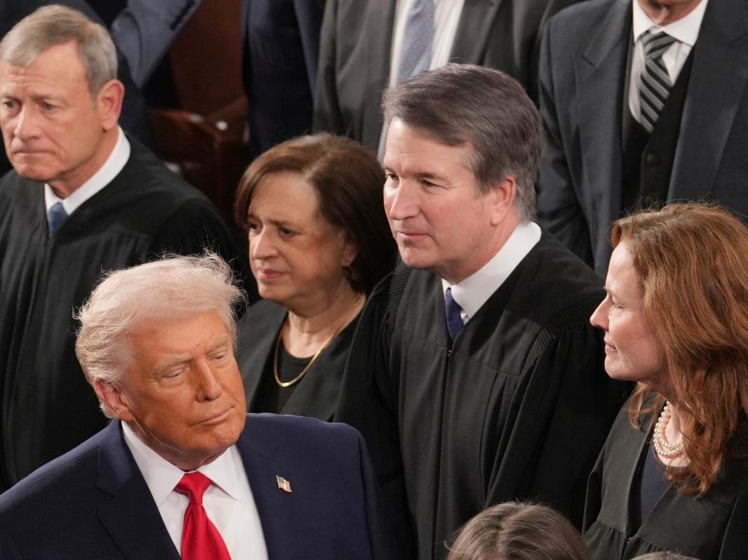 President Donald Trump walks by Chief Justice John Roberts, Justice Elena Kagan, Justice Brett Kavanaugh and Justice Amy Coney Barrett in February before his State of the Union address. 