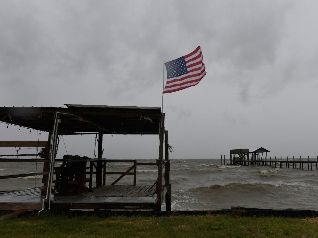 An American flag flaps in the wind generated by the effects of Isaias on an empty beach on Friday, Oct. 9, loom overhead on Friday, Oct. 9, 2026, in Mon Louis Island, Alabama.