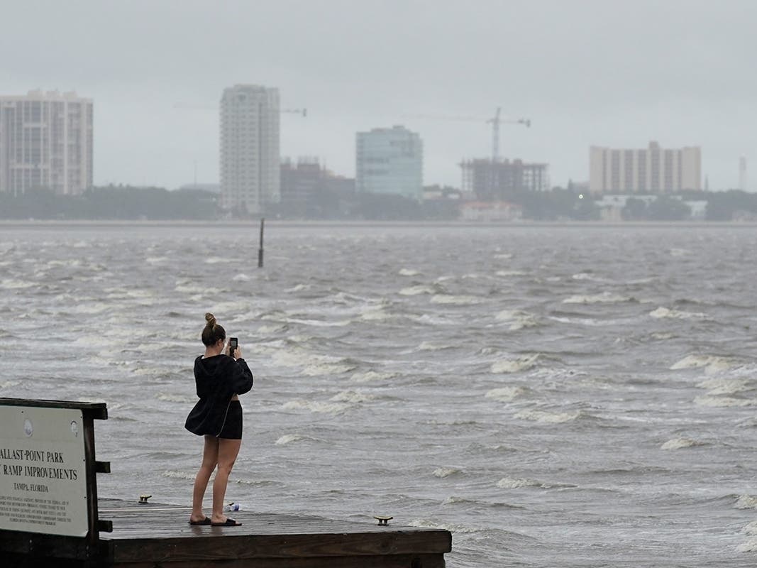 A woman takes photos of the surf on Tampa Bay ahead of Hurricane Ian, Wednesday, Sept. 28, 2022, in Tampa, Fla.