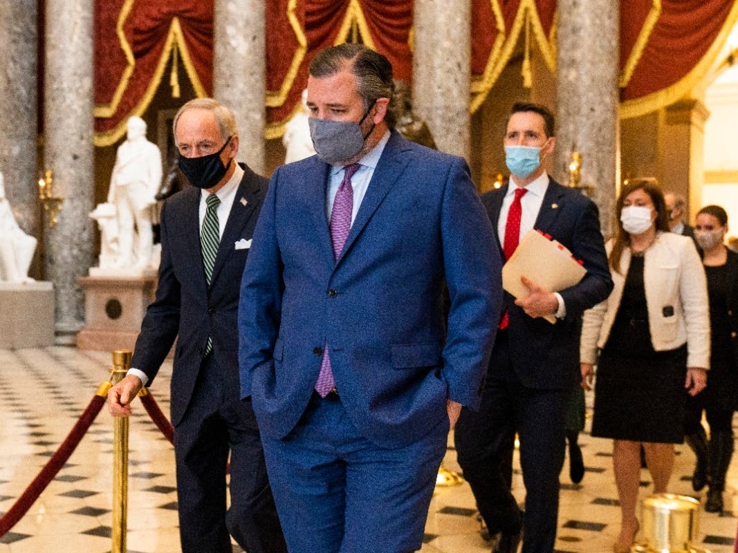 Sen. Ted Cruz, R-Texas, front, followed by Sen. Josh Hawley, R-Mo., walk from the House Chamber following a Senate procession carrying boxes holding Electoral College votes to the House Chamber for a joint session to confirm the Electoral College votes. 