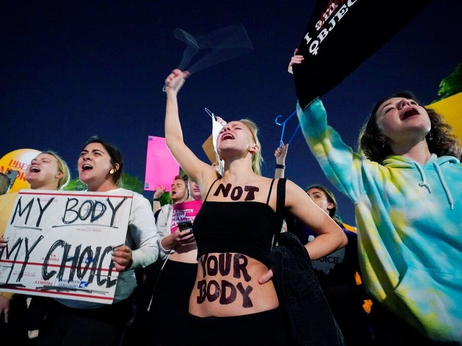 A crowd of people gather outside the Supreme Court, early Tuesday, May 3, in Washington. 