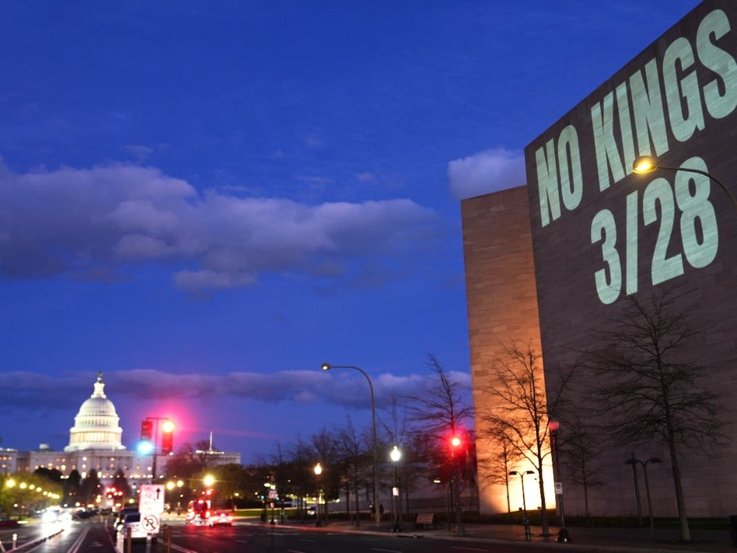 A message promoting an upcoming "No Kings" protest is projected on the National Gallery of Art, with the U.S. Capitol seen in the background, Monday, March 23, 2026, in Washington. 