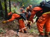 A California Department of Corrections crew builds a containment line along Highway 9 to prevent the spread of the CZU August Lightning Complex Fire, Saturday, Aug. 22, 2020, in Boulder Creek, Calif. 