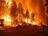 Gabe Huck (right), a member of a San Benito Monterey Cal Fire crew, stands along state Highway 168 while fighting the Creek Fire on Sunday in Shaver Lake, Calif. 