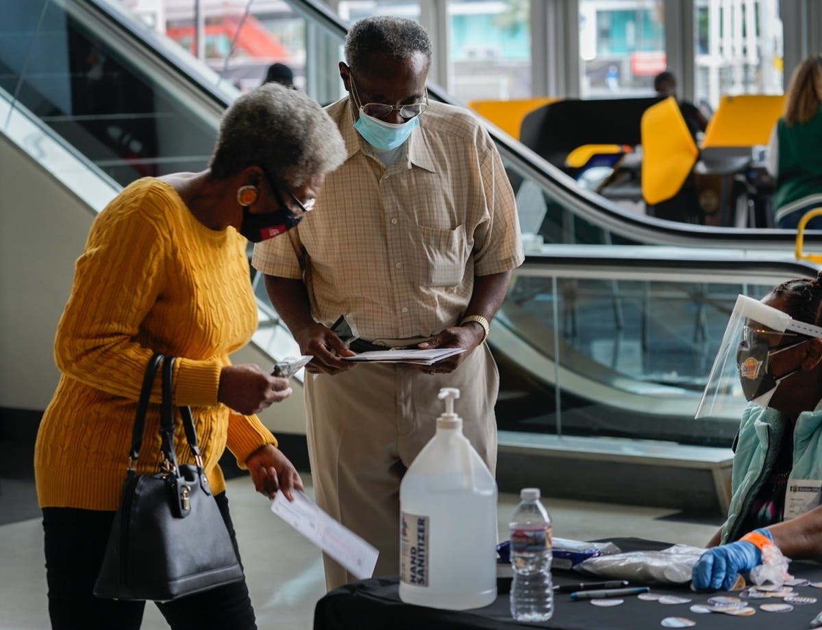 People vote on the first day of early voting inside the Vote Center at Staples Center sports and entertainment arena in Los Angeles Saturday, Oct. 24, 2020.