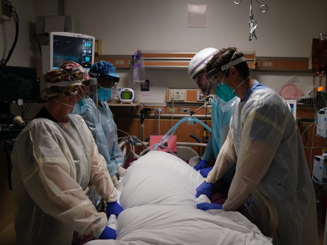 Medical workers prepare to manually prone a COVID-19 patient Dec. 22 in an intensive care unit at Providence Holy Cross Medical Center in the Mission Hills section of Los Angeles. 