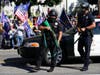 Police officers hold weapons in front of a crowd of President Donald Trump supporters outside of City Hall Wednesday, Jan. 6, 2021, in Los Angeles. 