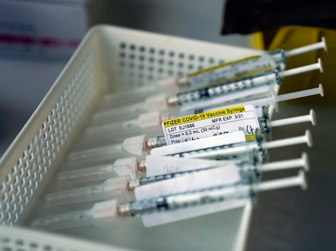 Syringes containing the Pfizer-BioNTech COVID-19 vaccine sit in a tray in a vaccination room at St. Joseph Hospital in Orange, Calif., Thursday, Jan. 7, 2021. 