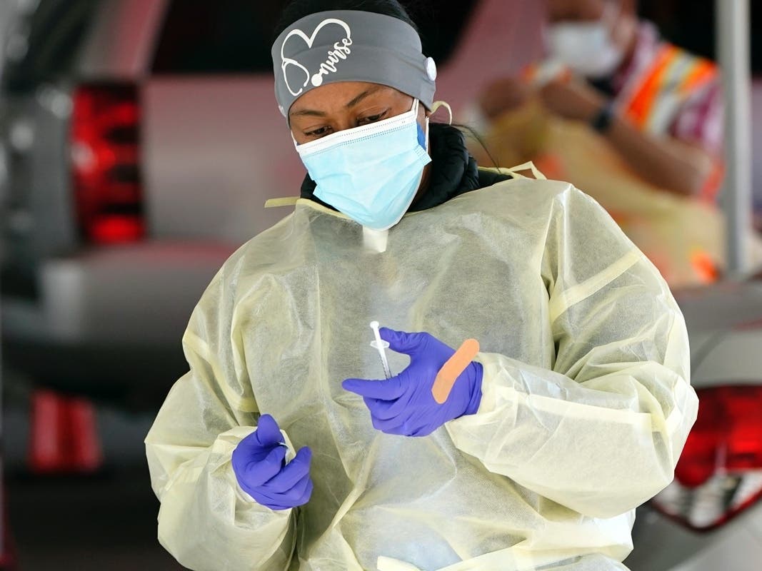 A nurse prepares to administer a COVID-19 vaccine at a vaccination site at The Forum Thursday in Inglewood.