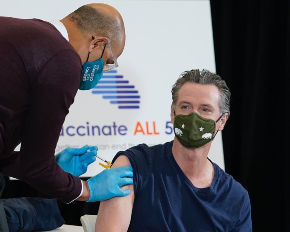 Dr. Mark Ghaly, Secretary, California Health and Human Services, left, inoculates California Gov. Gavin Newsom, right, at the Baldwin Hills Crenshaw Plaza in Los Angeles Thursday, April 1, 2021. Newsom was vaccinated with the new one-dose Janssen vaccine.