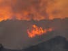 Flames from a brush fire in the Pacific Palisades area of Los Angeles Saturday, May 15, 2021.