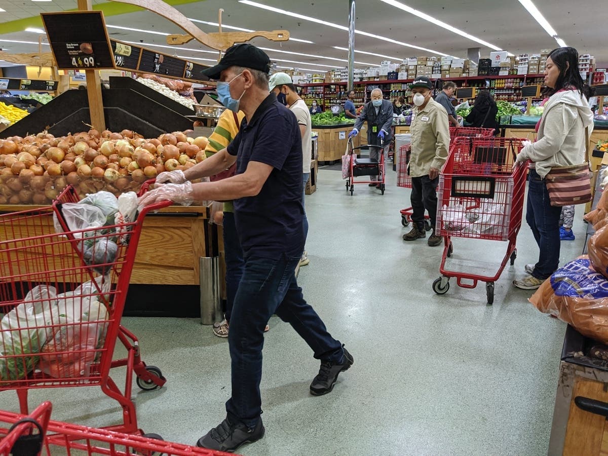 Customers at a Super King market wear face masks and gloves in April 2020 in Los Angeles to ward off the coronavirus.