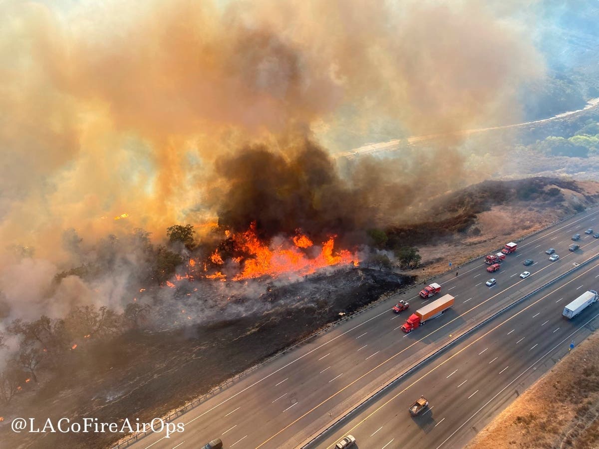 In this aerial photo released by the Los Angeles County Fire Department Air Operations traffic passes the Route fire, a brush wildfire off Interstate 5 north of Castaic, Calif., on Saturday, Sept. 11, 2021. 
