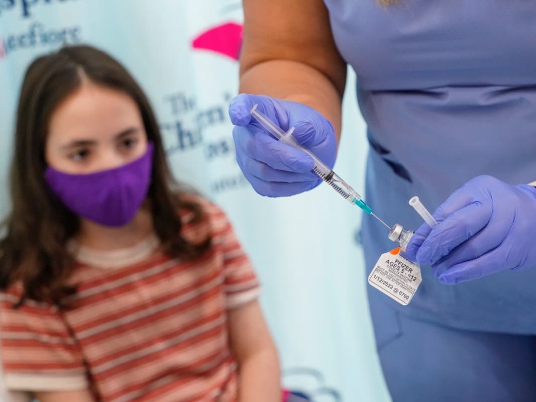 Jamie Onofrio Franceschini, 11, watches as RN Rosemary Lantigua prepares a syringe with her first dose of the Pfizer COVID-19 vaccine for children five to 12 years at The Children's Hospital at Montefiore, Nov. 3, 2021, in the Bronx borough of New York.