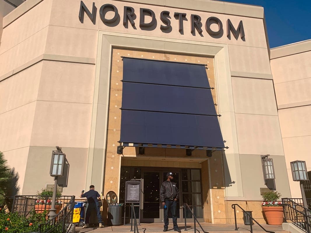 A security guard stands outside the Nordstrom store at The Grove retail and entertainment complex in Los Angeles, Tuesday, Nov. 23, 2021.